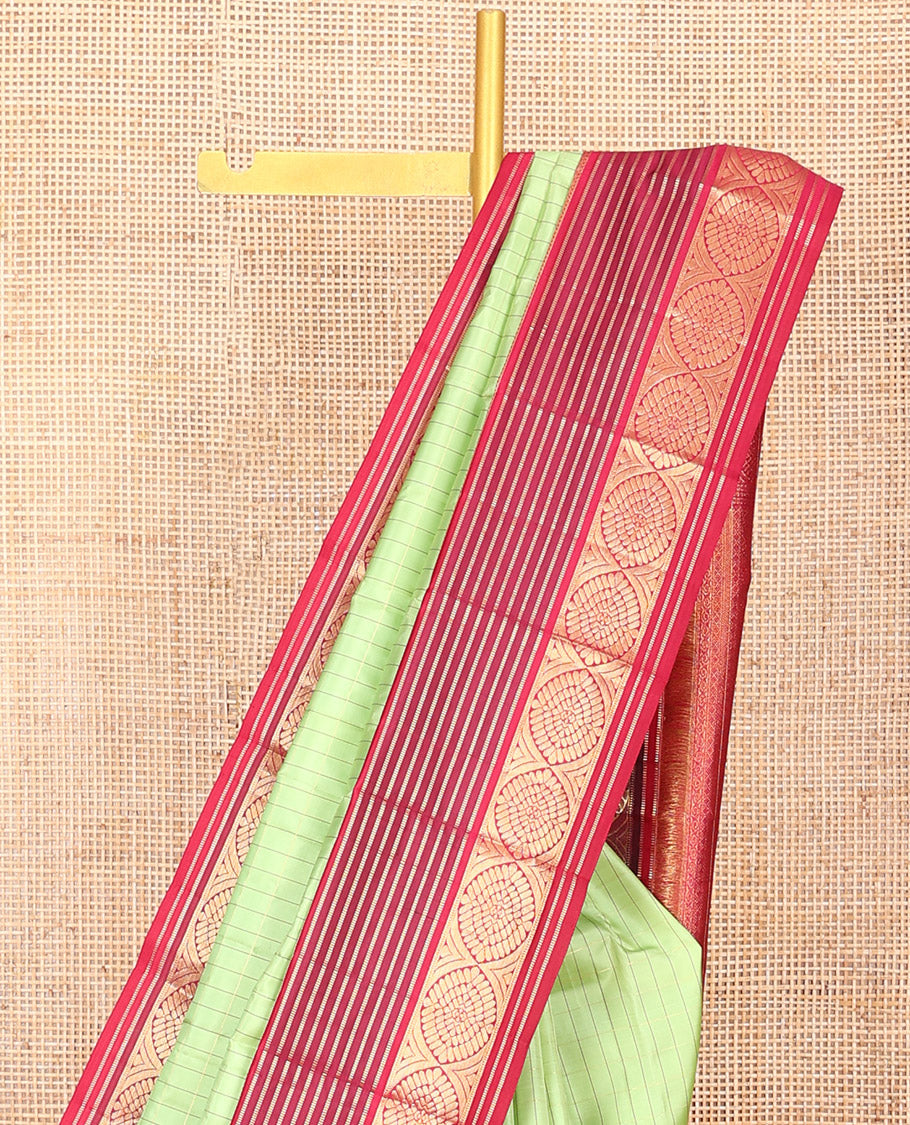 Green Vasundhara Silk Saree Subtly Sparkled with Stripes, Highlighted by a Contrast Border of Muthu, Diamond, Kamalam, and Laddu Kamalam Designs, Delicately Woven Pallu of Intricate Designs, and Paired with a Contrast Blouse