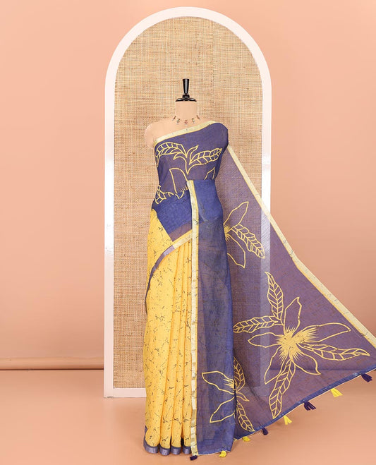 Yellow and blue batik and floral printed linen saree, contrast piping border, floral printed pallu, and a printed blouse