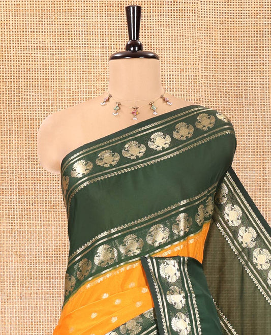 Orange Art Mysore Silk Saree, Decked Up with Zari Buttas All Over Its Body, Complemented by a Contrast Rettai Pettu Border of Two-Headed Eagle Designs, Pallu Steeped with Buttas and Stripes, and Paired with a Contrast Blouse