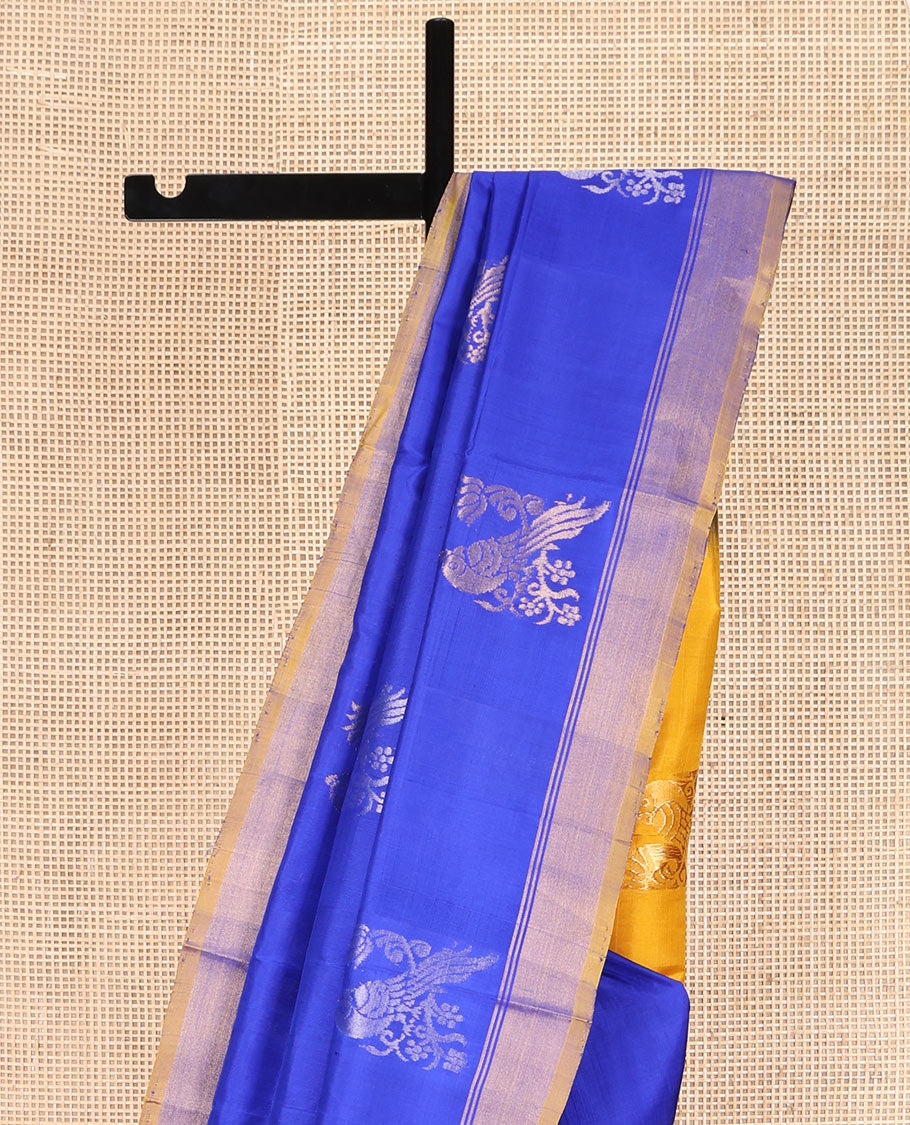 Blue Uppada Silk Saree, Showcasing Parrot Zari Buttas on Its Body, Subtle Zari Border, Complemented by a Contrast Pallu Depicting Parrot Zari Buttas, and Paired with a Contrast Blouse