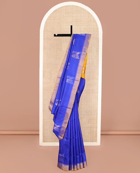 Blue Uppada Silk Saree, Showcasing Parrot Zari Buttas on Its Body, Subtle Zari Border, Complemented by a Contrast Pallu Depicting Parrot Zari Buttas, and Paired with a Contrast Blouse