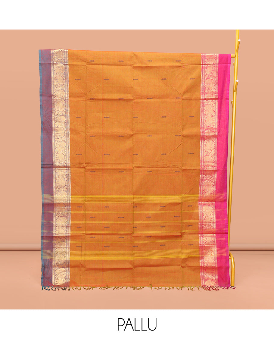 Orange Chettinad Cotton Saree, Finely Crafted with Buttas All Over Its Body, Complemented by a Contrast Ganga-Jamuna Kal Eragina Border of Kodi Peacock and Elephant Designs, Pallu of Buttas and Stripes, and Paired with a Matching Blouse