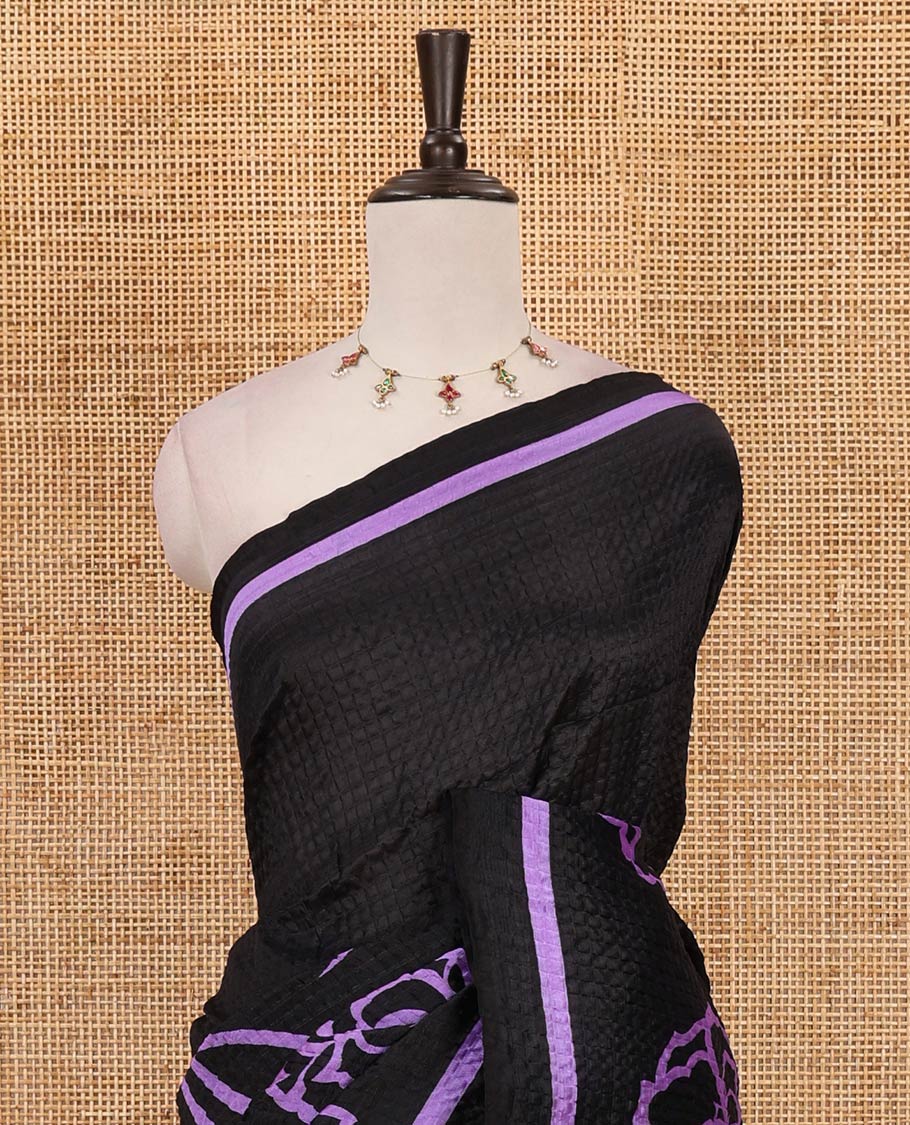 Black-base crushed litchi saree features fancy violet color floral printed body, printed piping border & pallu