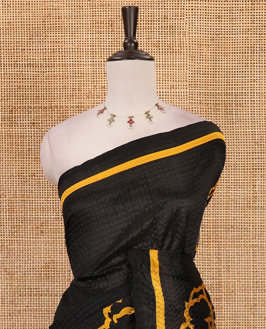 Black-base crushed litchi saree features fancy yellow color floral printed body, printed piping border & pallu