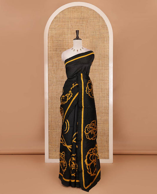 Black-base crushed litchi saree features fancy yellow color floral printed body, printed piping border & pallu
