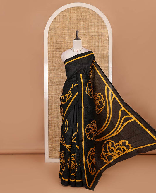 Black-base crushed litchi saree features fancy yellow color floral printed body, printed piping border & pallu