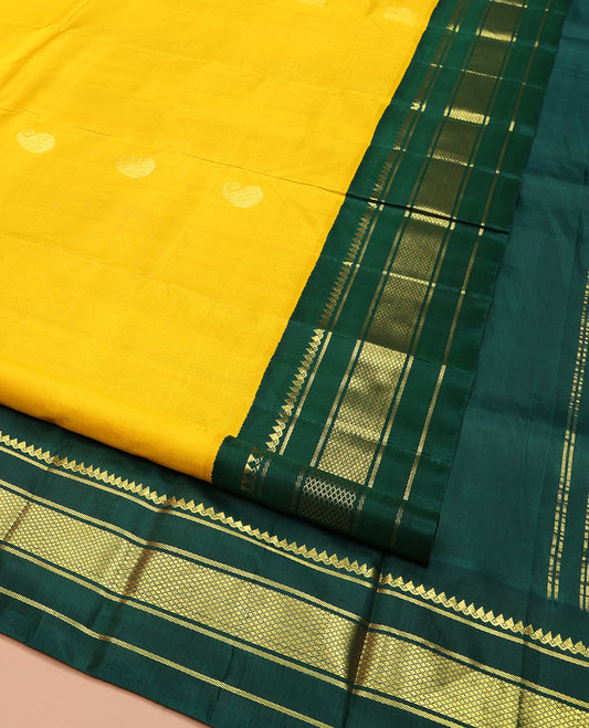 Yellow Kanchipuram Silk Saree, Adorned with Manga and Mayil Buttas, Complemented by Contrast One-Sided Korvai Border of Thilakam Mokku, Banaras, and Kuyil Kann Designs, Pallu Steeped with Mayil Designs, and Comes Without a Blouse