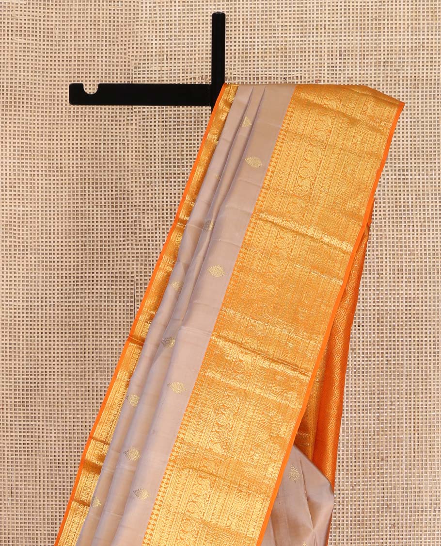 Sandal Kanchipuram Silk Saree, Finely Crafted with Zari Buttas All Over Its Body, Complemented by a Contrast Border of Thilakam Mokku, Poun, Neli, Mayil, and Kuthirai Designs, Pallu of Jaal Designs, and Paired with a Contrast Blouse
