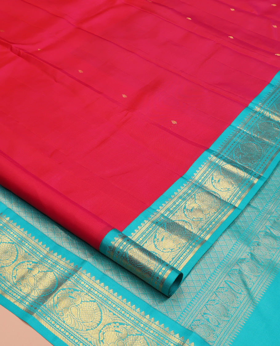 Red Vasundhara Silk Saree, Subtly Sparkled With Zari Buttas All Over Its Body, Complemented by Zari Buttas All Over Its Body, Complemented by Contrast Border of Thilakam, Banaras, and Mayil Designs Grand Jaal Pallu and Paired with a Contrast Blouse