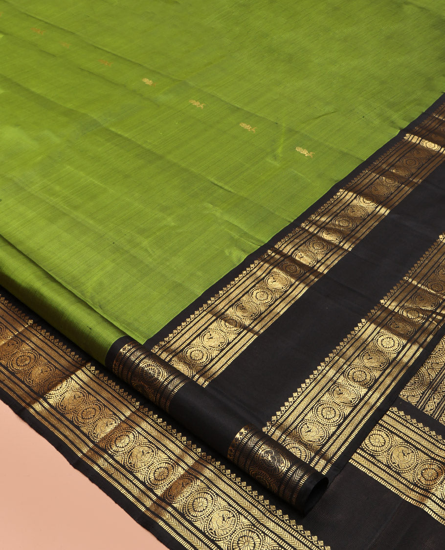 Green Kanchipuram Silk Saree, Ornamented with Zari Buttas All Over Its Body, Complemented by a Contrast Rettai Pettu Border of Salngai, Muthu, Kathir, Chakram, and Round Mayil Designs, Grand Pallu, and Paired with a Contrast Blouse