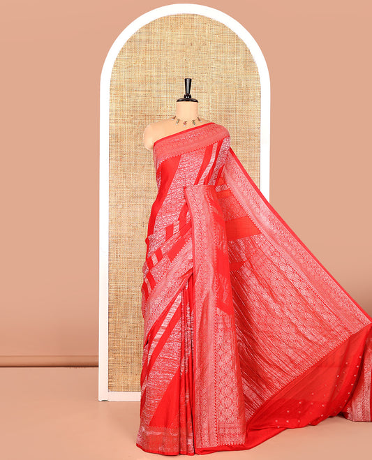 Red geometric and intricate designs zari woven fancy crepe saree, traditional zari border, floral-star gridded pallu, and a matching blouse