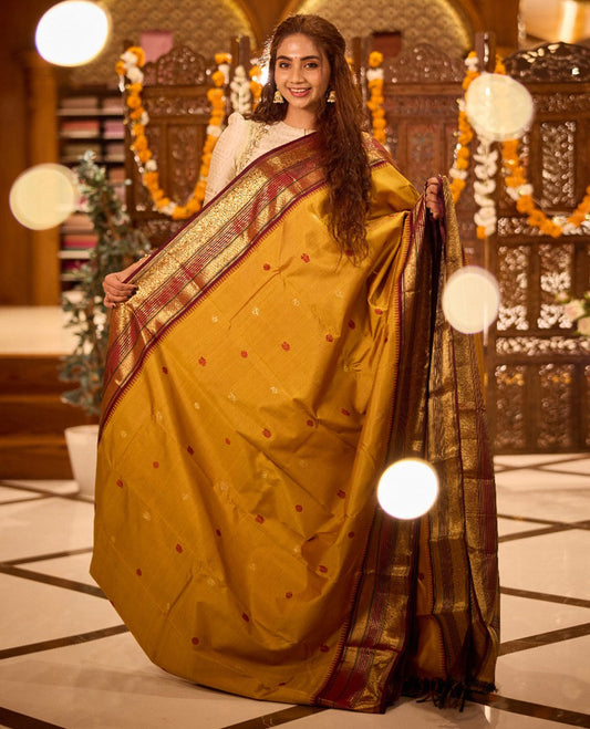 Mustard thread and zari woven mayil buttas Kanchipuram silk saree, contrast border features thazampoo rekku, then kuli kann, bogudi, godhumai kann, and Mayil designs, and intricate pallu