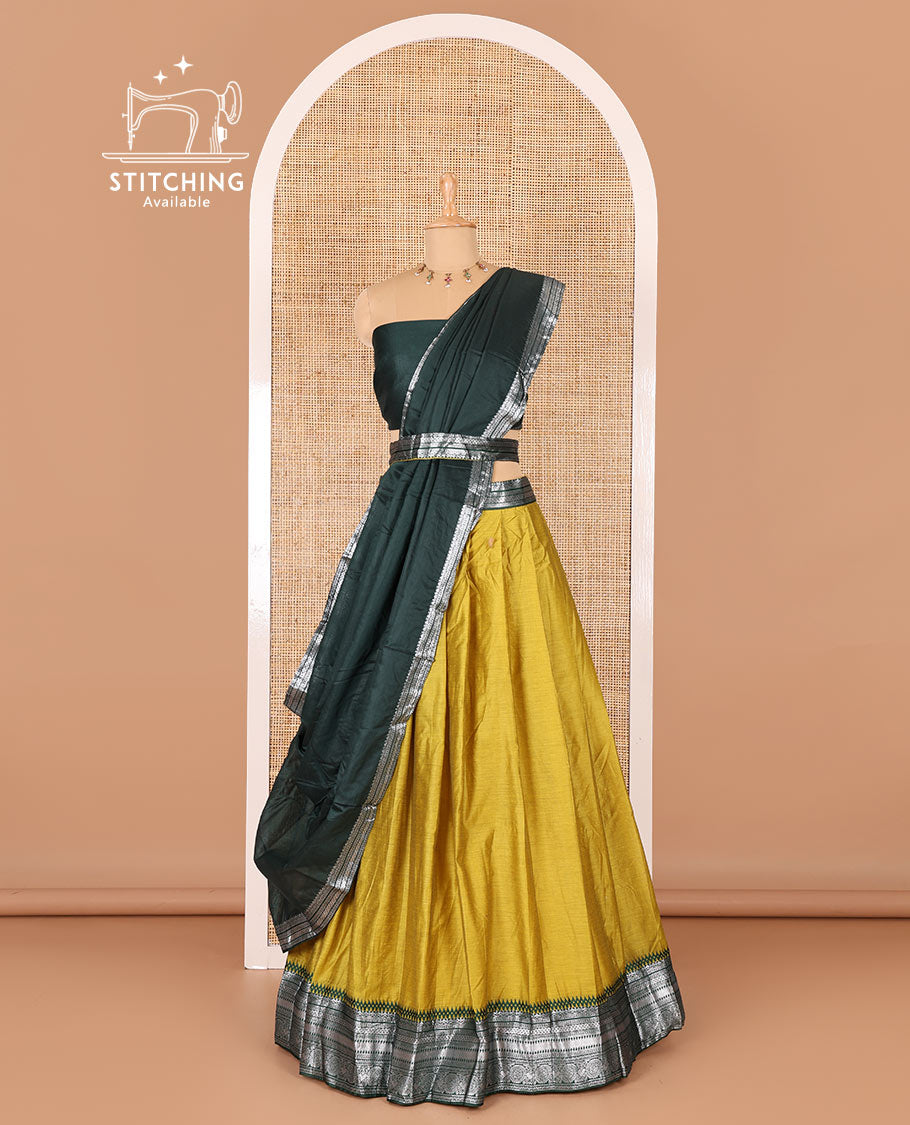 Manga yellow taffeta silk half-saree, plain with a contrast traditional design bordered skirt, contrast blouse, and traditional zari bordered blouse