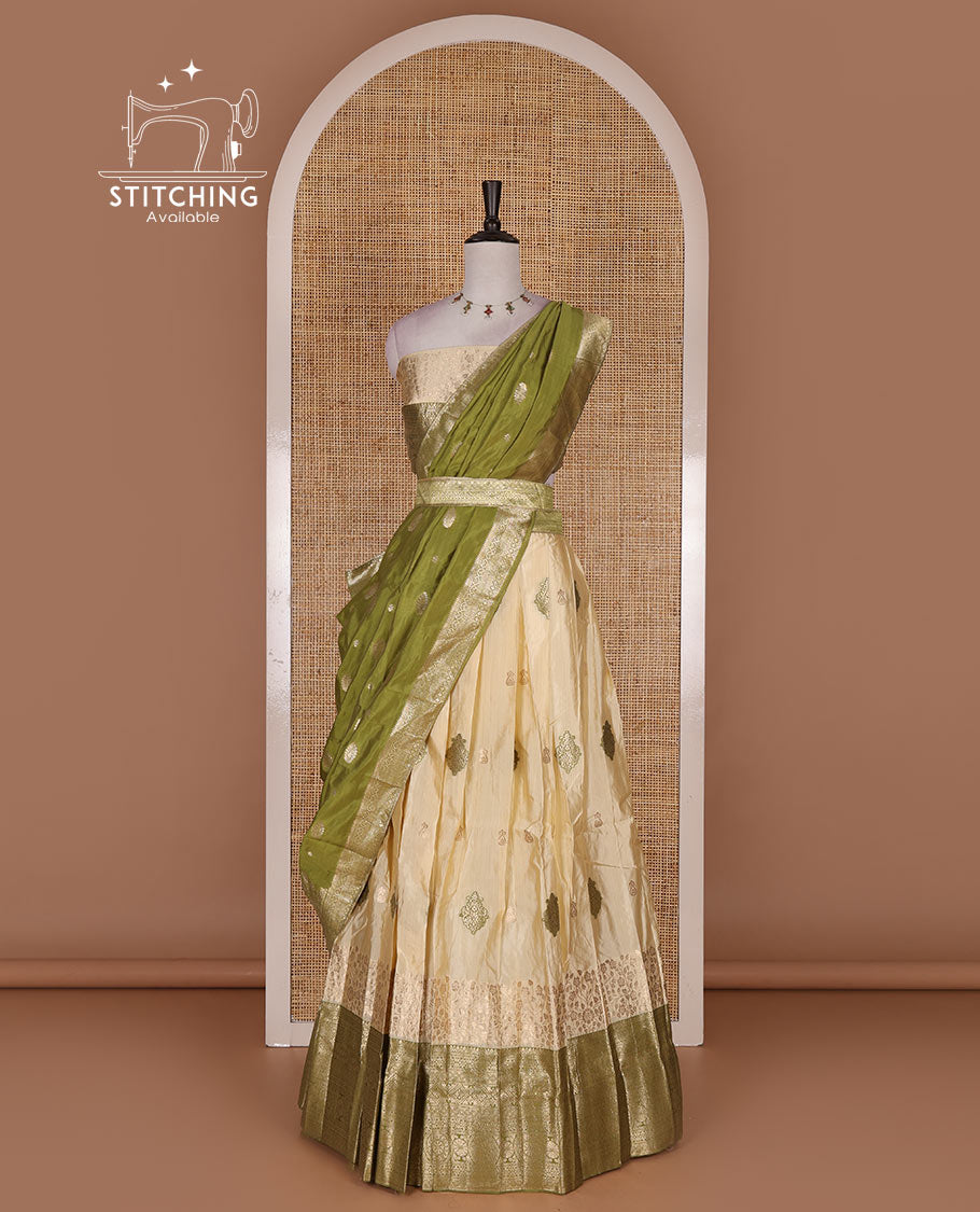 Cream taffeta silk half saree, meena buttas skirt, contrast mehendi green  traditional zari border, matching blouse, and zari woven dhavani