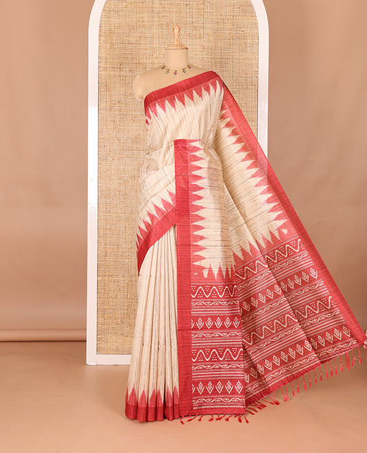 Chikku-red plain Khicha katan silk saree, contrast red temple border, ikkat printed pallu with tassels, and a contrast blouse