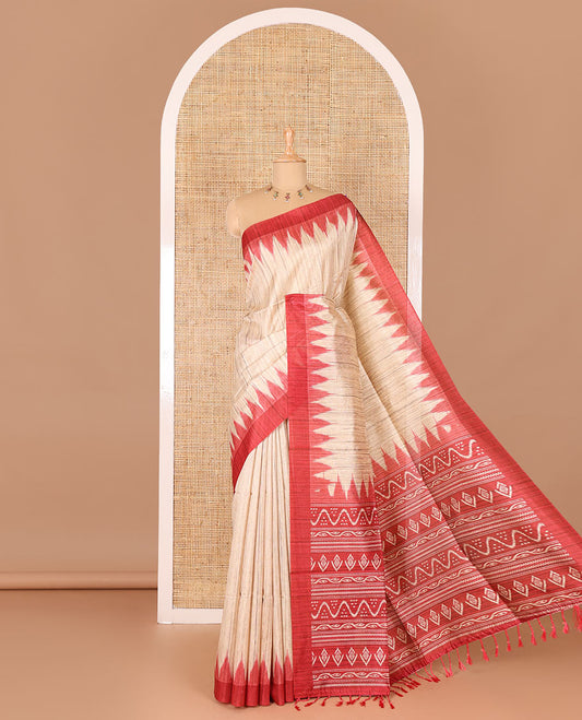 Chikku-red plain Khicha katan silk saree, contrast red temple border, ikkat printed pallu with tassels, and a contrast blouse