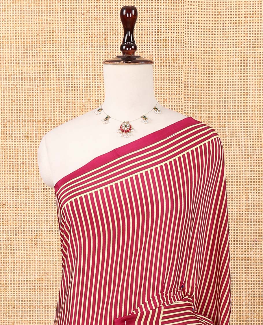 Magenta vertical stripes printed modal satin saree, a self-border of horizontal stripes print, polka dots printed on the pallu, and an intricate ajrakh-style printed blouse