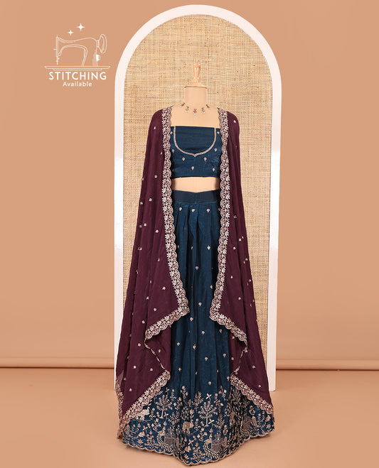 Peacock blue half-saree, buttas and flora-fauna embroidered bordered velvet organza skirt, a matching velvet organza blouse, and a contrast embroidered scallop syska georgette dhavanif