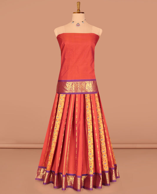 Rust Art Silk Pavadai Material Set, Bedecked with Zari Designs on Its Skirt, Complemented by a Contrast Traditional Zari Border, and a Matching Blouse