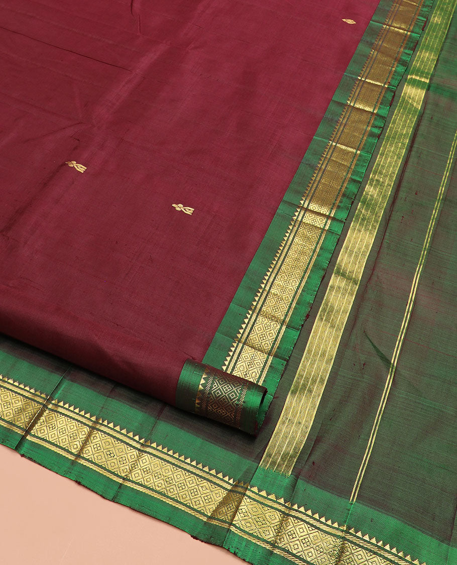 Maroon Kanchipuram Silk Saree Elevated with Zari Buttas All Over Its Body, Complemented by Contrast One-Sided Border of Rekku, Banaras, and Mayil Kann Designs, Pallu of Zari Designs, and Comes Without a Blouse