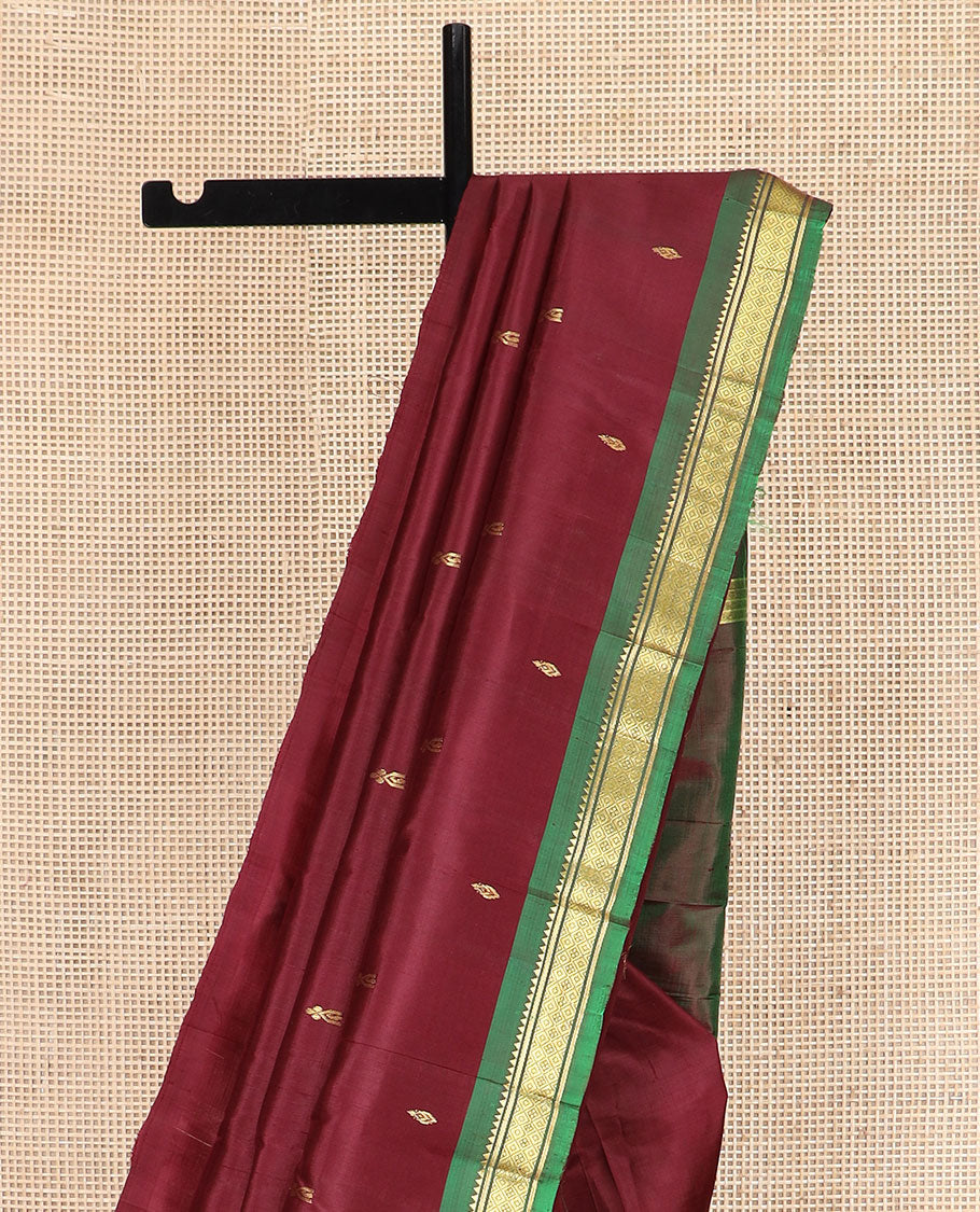 Maroon Kanchipuram Silk Saree Elevated with Zari Buttas All Over Its Body, Complemented by Contrast One-Sided Border of Rekku, Banaras, and Mayil Kann Designs, Pallu of Zari Designs, and Comes Without a Blouse