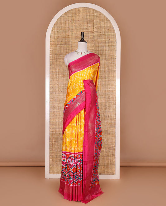 Yellow bandhani dotted dola silk saree, contrast patola style animal motifs enclosed diamond gird zari border, and contrast printed blouse