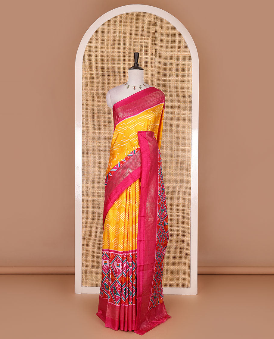 Yellow bandhani dotted dola silk saree, contrast patola style animal motifs enclosed diamond gird zari border, and contrast printed blouse