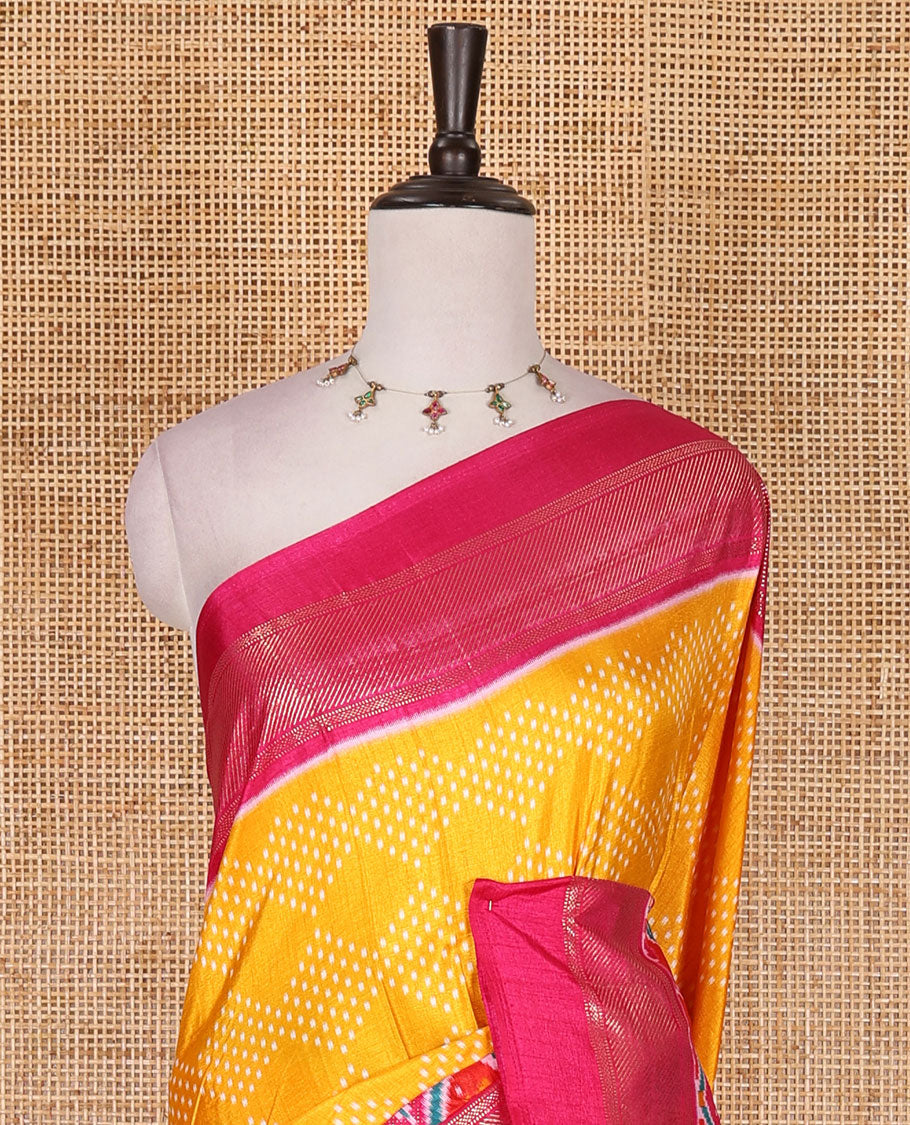 Yellow bandhani dotted dola silk saree, contrast patola style animal motifs enclosed diamond gird zari border, and contrast printed blouse