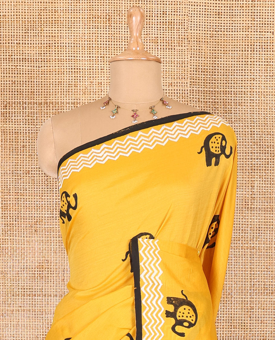 Yellow elephant motifs block printed South cotton saree, chevron stripes block printed border, a matching blouse, and a contrast floral vine printed blouse