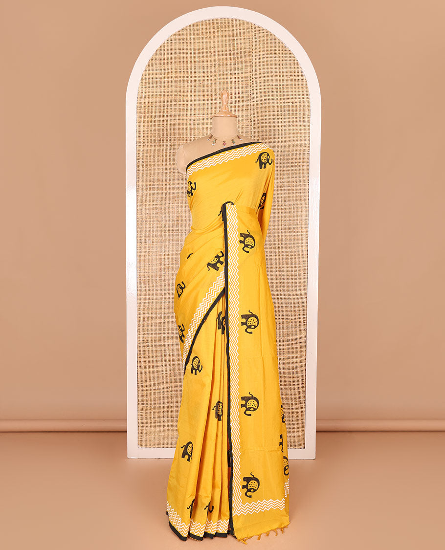 Yellow elephant motifs block printed South cotton saree, chevron stripes block printed border, a matching blouse, and a contrast floral vine printed blouse