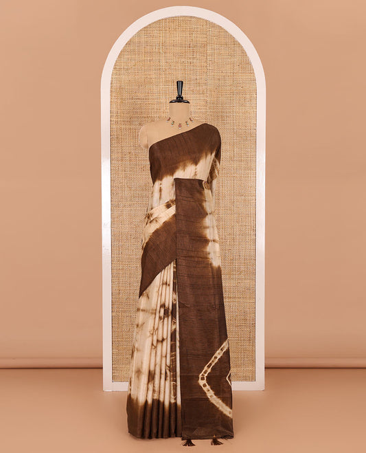 Brown shibori printed jute cotton saree, contrast plain border, plain pallu with tussels, and contrast plain blouse