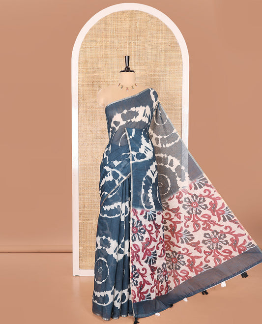Borderless Petrol Blue Linen Cotton Saree Elevated with Shibori Prints, Complemented by Contrast Pallu Steeped with Floral Vine Print, and Paired with a Contrast Floral Printed Blouse