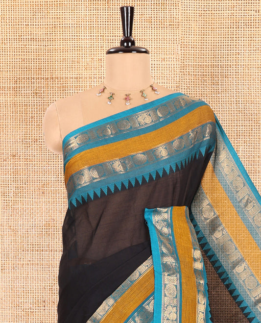 Black Plain Chettinad Cotton Saree, Complemented with a Contrasting Rettai Pettu Border of Peacock Chakram Motifs, a Subtle Pallu of Stripes, and a Matching Blouse