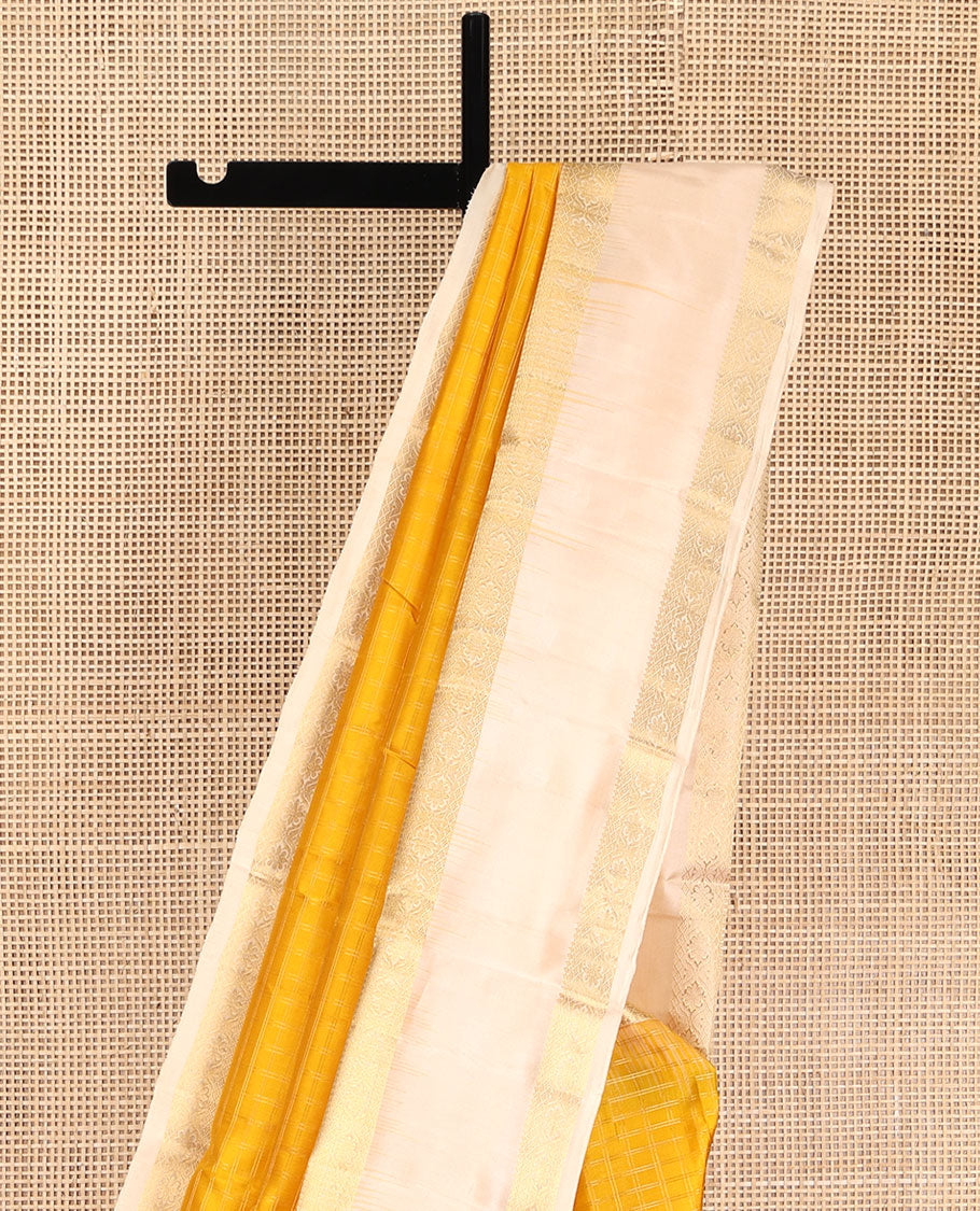 Yellow Vasundhara Silk Saree, Subtly Sparkled with Checked All Over Its Body, Complemented by Contrast Rettai Pettu Border of Thilakam Mokku, and Cross Kamalam Designs, Pallu of Jaal Designs, and Paired with a Contrast Blouse