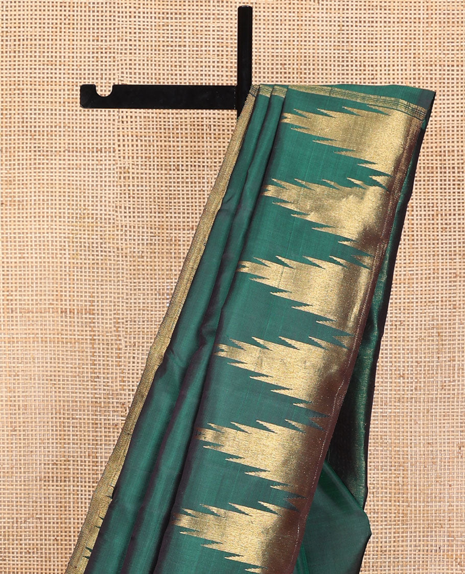 Green plain Kanchipuram silk saree, gleaming antique golden zari colored thazampoo rekku border, and zari-rich pallu of seppu rekku design