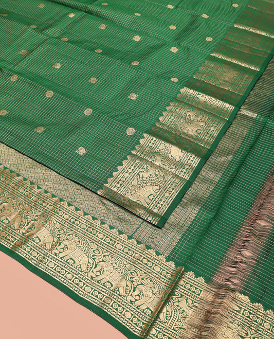 Green Vasundhara Silk Saree Gleamed Up with Zari Checks and Annam Chakram Buttas, Complemented by a Zari Border of Thazampoo Rekku, Neli, Rudraksham, Diamond and Yaanai Designs, Zari Embellished Pallu of Jaal Designs, and Paired with a Matching Blouse