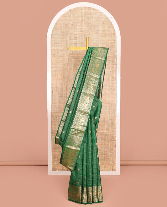 Green Vasundhara Silk Saree Gleamed Up with Zari Checks and Annam Chakram Buttas, Complemented by a Zari Border of Thazampoo Rekku, Neli, Rudraksham, Diamond and Yaanai Designs, Zari Embellished Pallu of Jaal Designs, and Paired with a Matching Blouse