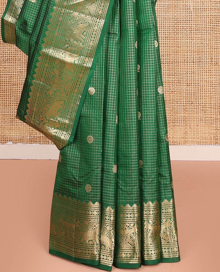 Green Vasundhara Silk Saree Gleamed Up with Zari Checks and Annam Chakram Buttas, Complemented by a Zari Border of Thazampoo Rekku, Neli, Rudraksham, Diamond and Yaanai Designs, Zari Embellished Pallu of Jaal Designs, and Paired with a Matching Blouse