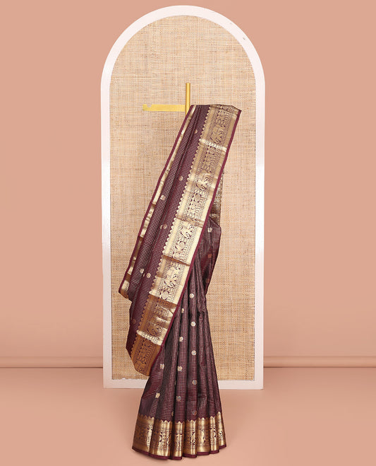 Brown Vasundhara Silk Saree Gleamed Up with Zari Checks and Annam Chakram Buttas, Complemented by a Zari Border of Thazampoo Rekku, Banaras, Paisa, Manga, and Mayil Designs, Elegantly Embellished Pallu, and Paired with a Matching Blouse