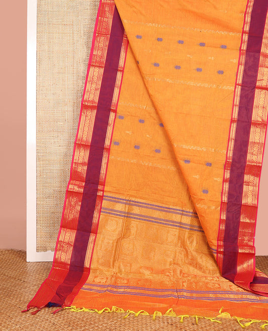 Orange Chettinad Cotton Saree Adorned with Floral Thread Buttas All Over Its Body, Complemented by Contrast Rettai Pettu Border of Traditional Designs, Pallu of Peacock and Yaali Butta Enclosed Checks, and Paired with a Matching Blouse