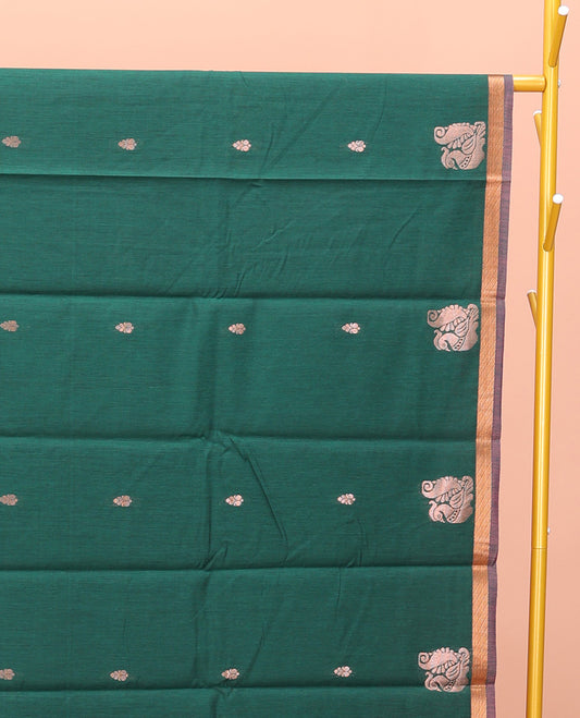 Bottle Green Semi-Silk Cotton Saree, Impeccably Designed with Peacock Zari Buttas on Its Body, Complemented by a Contrast Border of Peacock Designs, Pallu Steeped with Peacock Zari Design, and Paired with a Matching Blouse