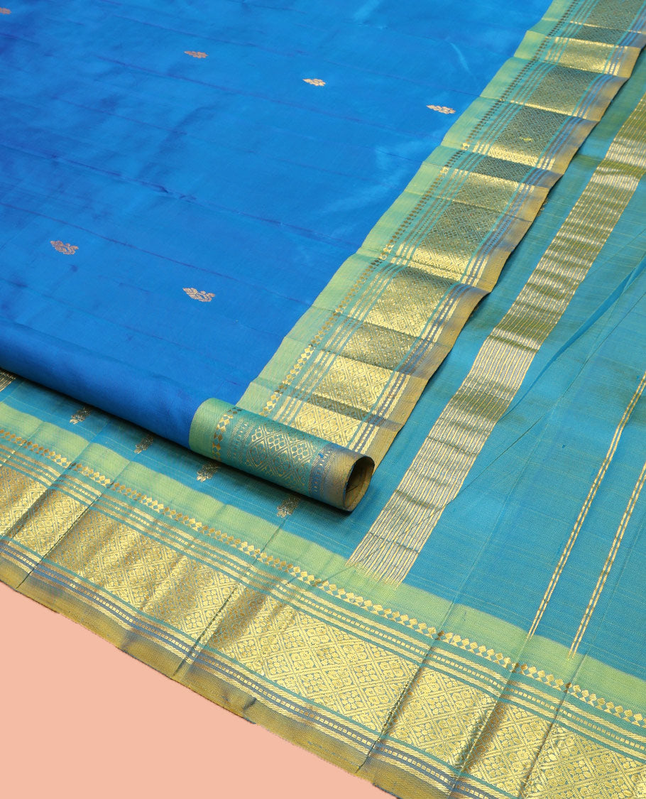 Blue Kanchipuram Silk Saree, Spotlighted with Zari Buttas on Its Body, Complemented by Contrast One-Sided Border of Panner Sombu, Banaras, Muthu, and Jaal Designs, Pallu Features Zari Designs, and Comes Without a Blouse