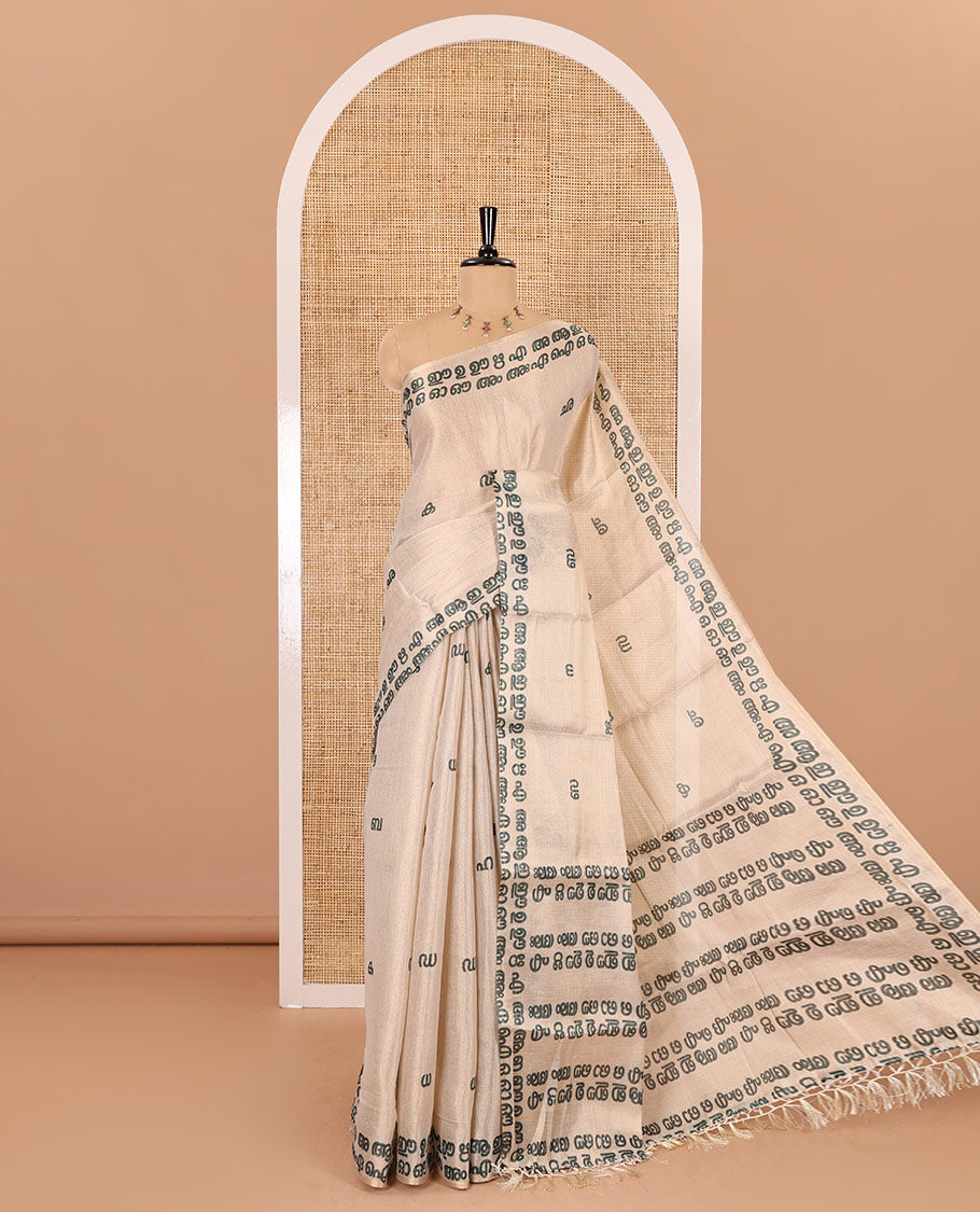 Cream-green Malayalam letter printed tissue saree, self-border and pallu steeped with Malayalam letter motifs, and a contrast plain blouse