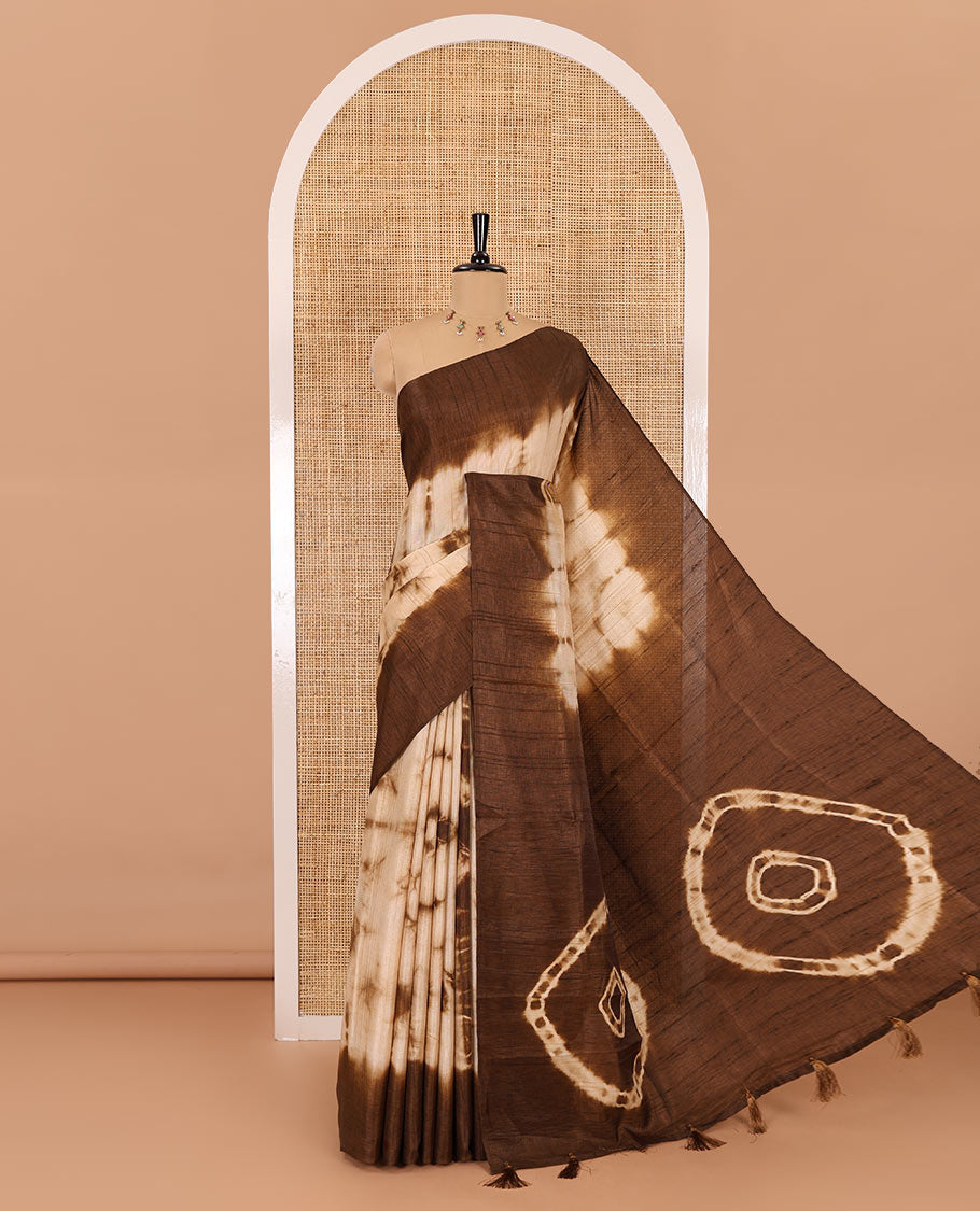 Brown shibori printed jute cotton saree, contrast plain border, plain pallu with tussels, and contrast plain blouse