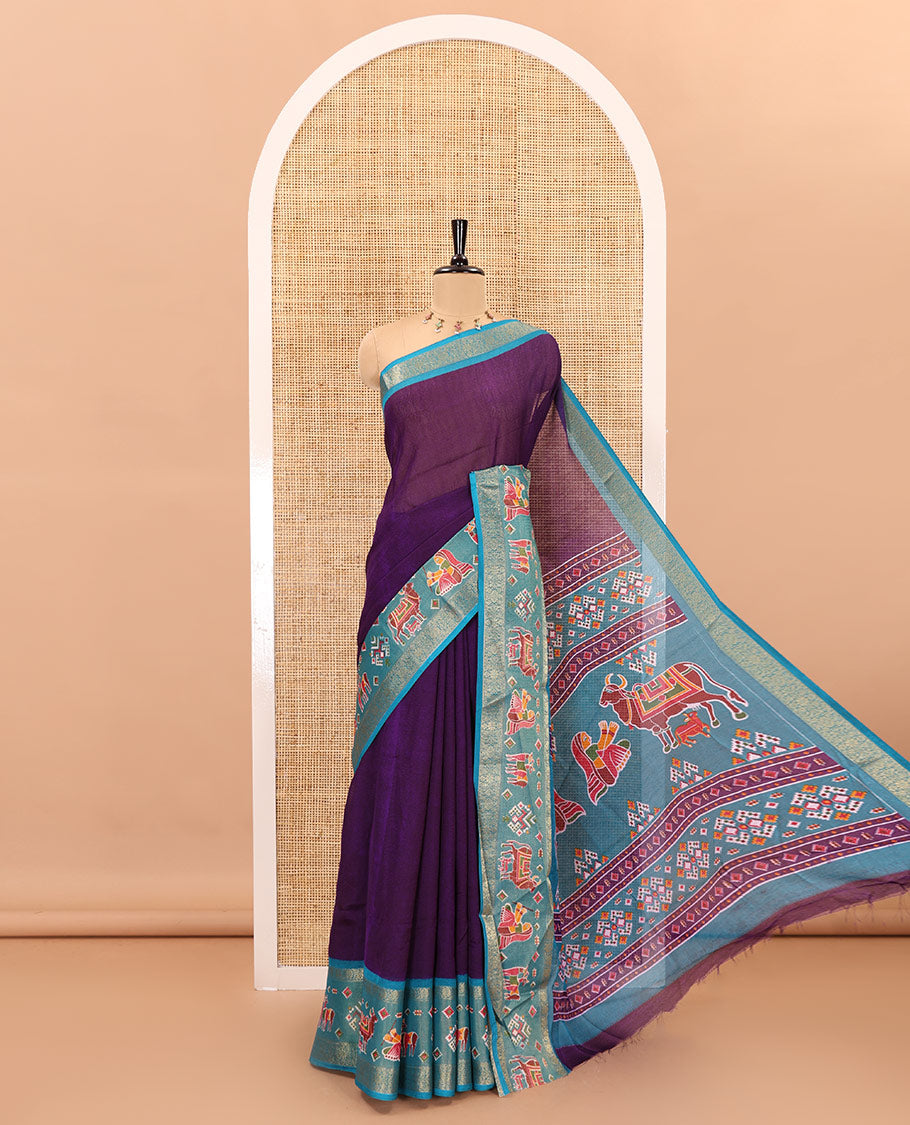 Violet embossed moss chiffon saree, contrast zari and colorfully printed border and pallu of human figurines and Pichwai cows, and embossed blouse