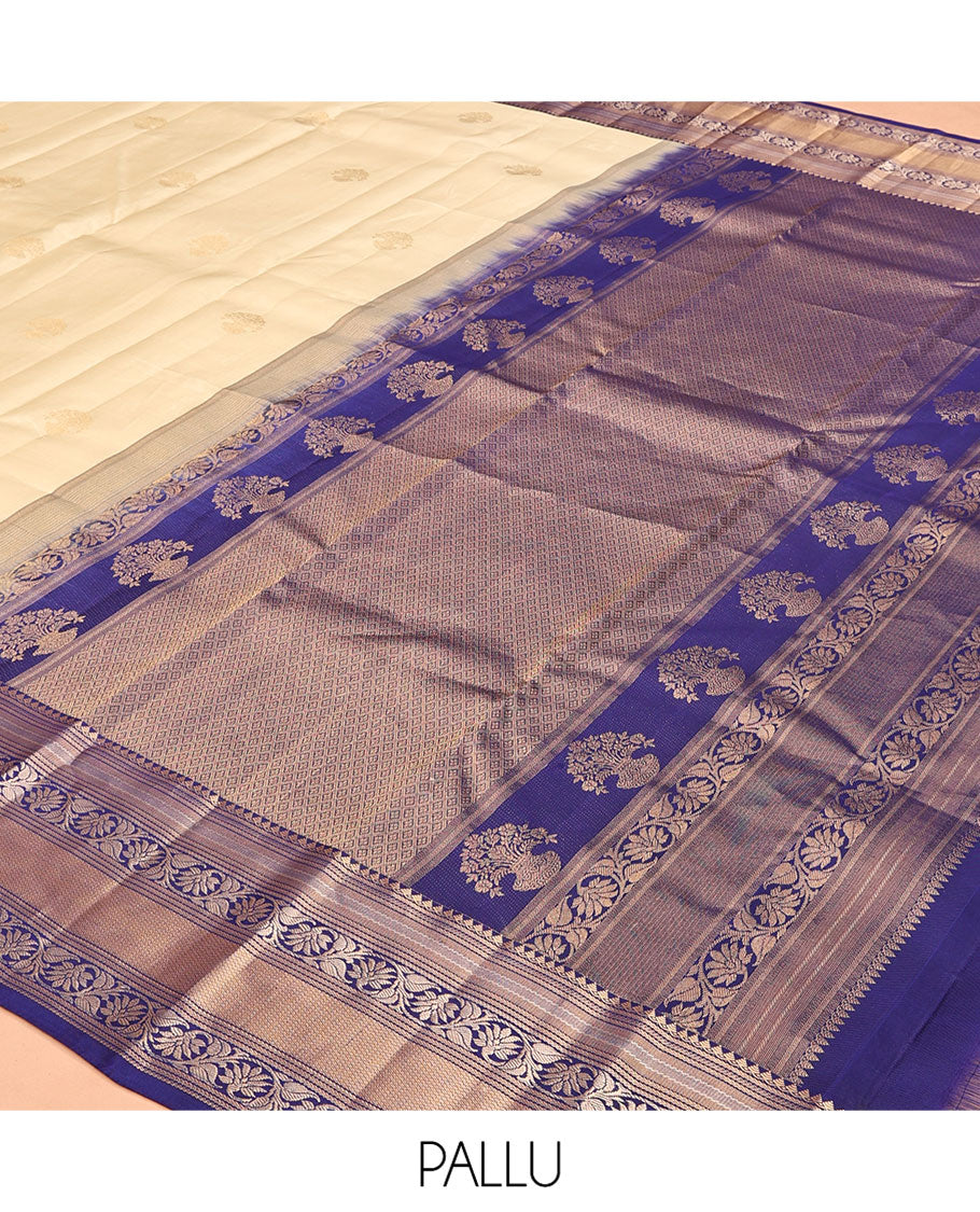 Sandal Vasundhara Silk Saree, Sparsely Sparkled with Zari Buttas, Complemented by a Contrast Border of Thilakam Mokku, Kodi Visiry, and Mayil Kann Designs, Jaal Pallu, and a Contrast Blouse