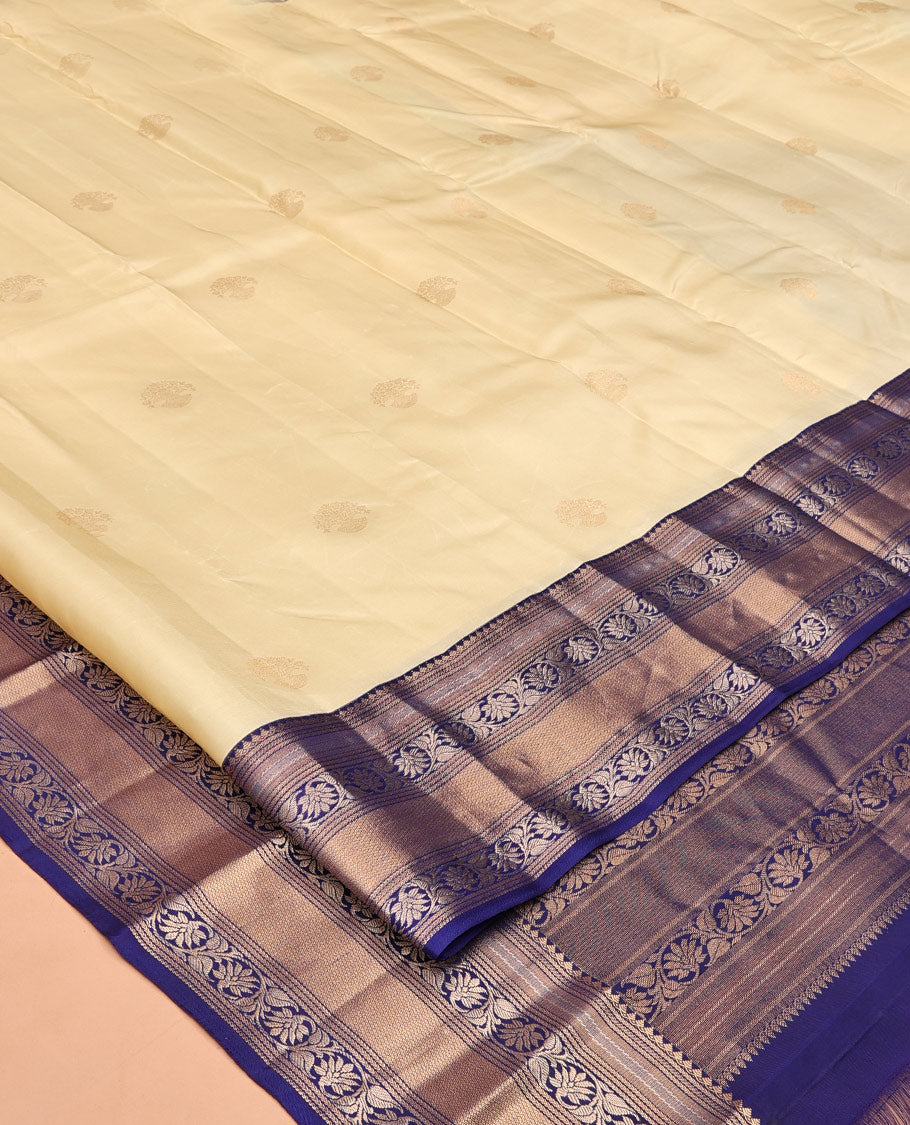 Sandal Vasundhara Silk Saree, Sparsely Sparkled with Zari Buttas, Complemented by a Contrast Border of Thilakam Mokku, Kodi Visiry, and Mayil Kann Designs, Jaal Pallu, and a Contrast Blouse