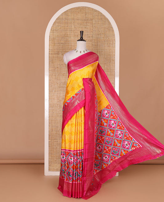 Yellow bandhani dotted dola silk saree, contrast patola style animal motifs enclosed diamond gird zari border, and contrast printed blouse