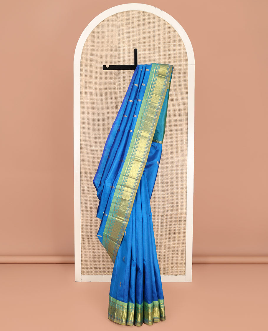 Blue Kanchipuram Silk Saree, Spotlighted with Zari Buttas on Its Body, Complemented by Contrast One-Sided Border of Panner Sombu, Banaras, Muthu, and Jaal Designs, Pallu Features Zari Designs, and Comes Without a Blouse