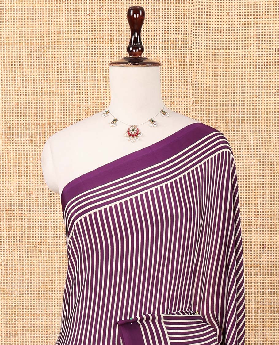 Purple vertical stripes printed modal satin saree, a self-border of horizontal stripes print, polka dots printed on the pallu, and an intricate ajrakh-style printed blouse